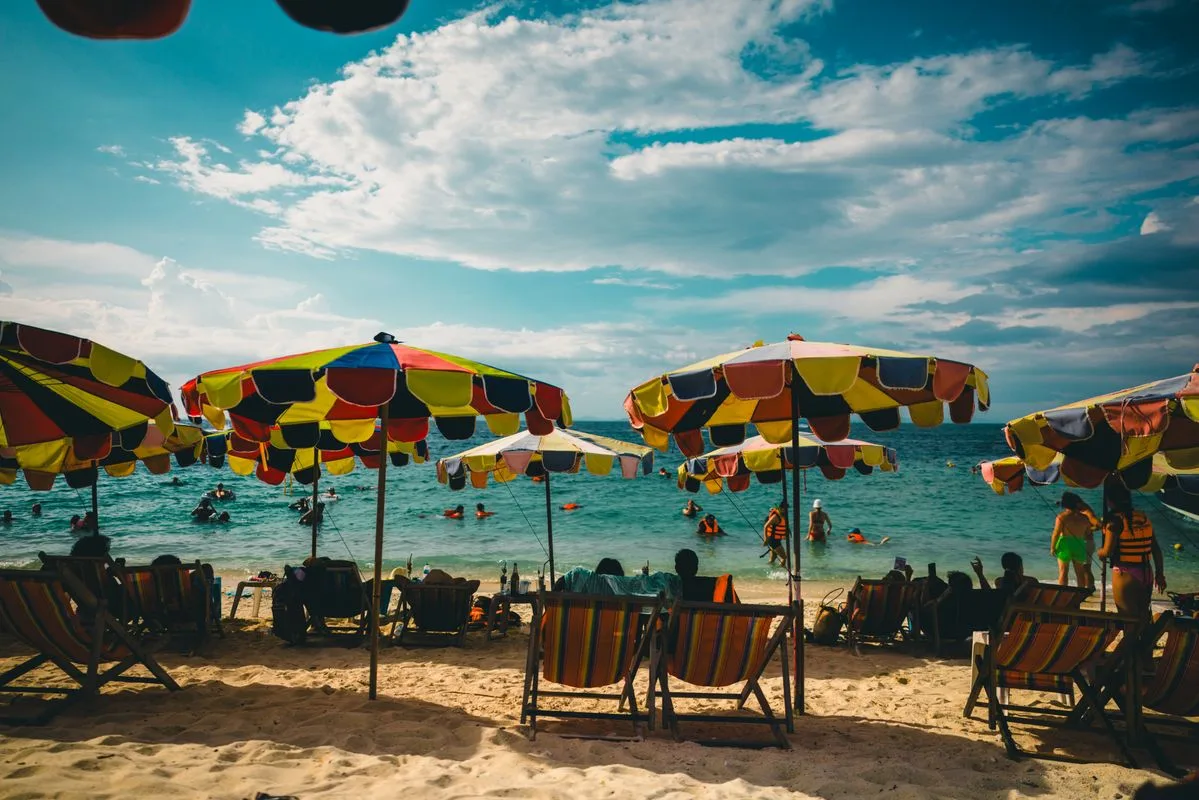 ชายหาดภูเก็ตพร้อมร่มสีสันและนักท่องเที่ยว
